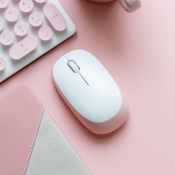 Photo of a white computer mouse on a pink desk