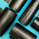 Rolls of black bin liners on a blue background